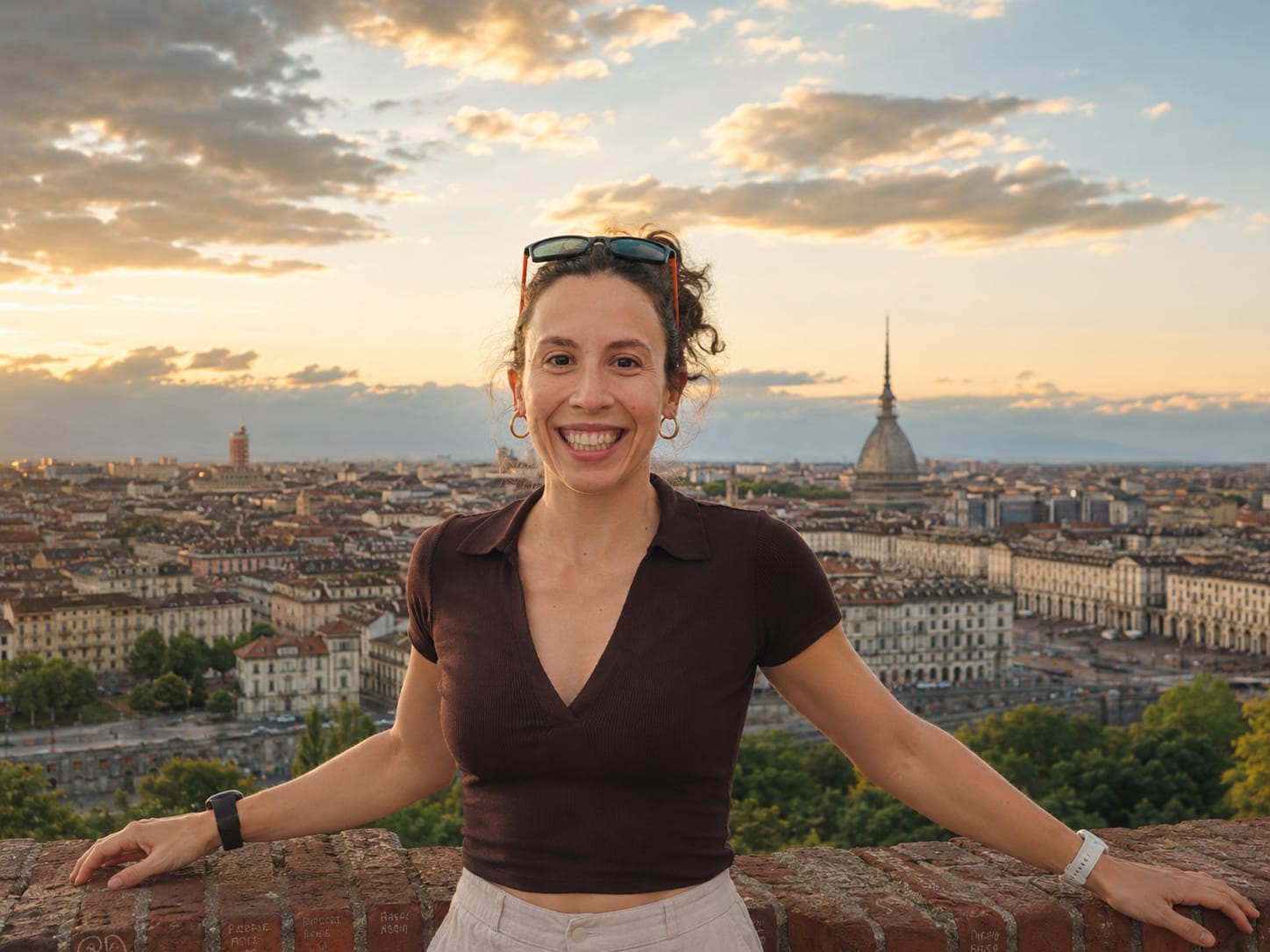 Erica Ferrari Trecate smiling above the Turin skyline at sunset.